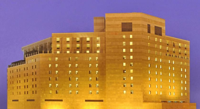 マカレム アイヤッド メッカ ホテル エクステリア 写真 The photo shows a large building, likely a hotel or a similar establishment. The structure is designed with a modern aesthetic, featuring a facade made of light-colored materials. The building has multiple floors, with several windows illuminated, su